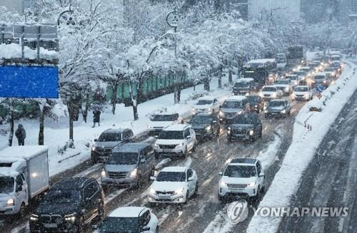 엉금엉금 출근길 (수원=연합뉴스) 홍기원 기자 = 이틀째 수도권 폭설이 이어지고 있는 28일 오전 경기도 수원시 팔달구 수원월드컵경기장 부근에서 차량이 서행하고 있다. 2024.11.28