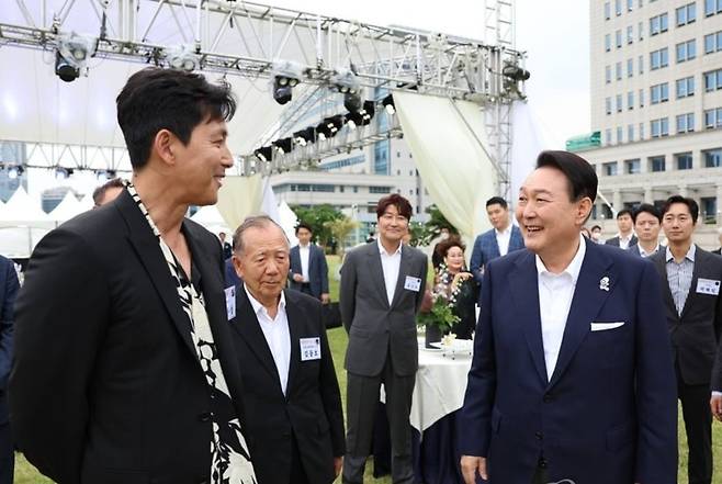 윤석열 대통령이 2022년 6월 12일 오후 서울 용산 대통령실 청사 잔디마당에서 열린 영화관계자 초청 만찬에서 배우 정우성과 대화하는 모습. (사진=연합뉴스)