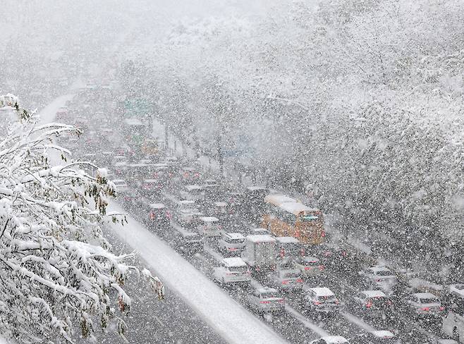 서울·경기지역에 기록적인 폭설이 내린 27일 서울 서초구 반포대로 일대에서 차량들이 쏟아지는 눈을 맞으며 거북이 걸음을 하고 있다. 연합뉴스