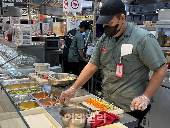 27일 인도네시아 자카르타에 위치한 롯데마트 간다리아씨티점 앞 푸드코트에서 현지 직원이 한국 대표 길거리 음식인 김밥을 싸고 있다.(사진=이데일리 김은비 기자)