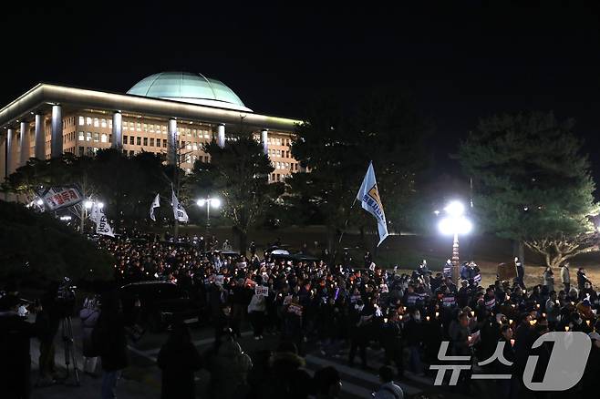 4일 오후 서울 여의도 국회 본청 앞 계단에서 열린 윤석열 대통령 사퇴촉구ㆍ탄핵 추진 범국민 촛불문화제를 마친 참가자들이 촛불을 들고 국회 경내를 행진하고 있다. 2024.12.4/뉴스1 ⓒ News1 이광호 기자