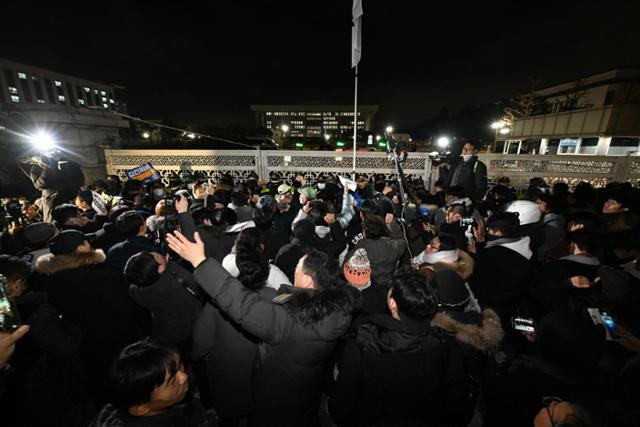 윤석열 대통령의 비상계엄 해제 요구 결의안이 국회 본회의에서 통과된 4일 새벽 국회 정문 앞에서 시민들이 윤 대통령 퇴진을 촉구하고 있다. 박시몬 기자