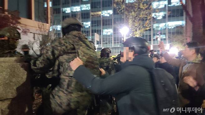 4일 오전0시 50분쯤 서울 여의도 국회의사당으로 진입하려는 군병력과 시민이 몸싸움을 벌이고 있다./사진=이찬종 기자