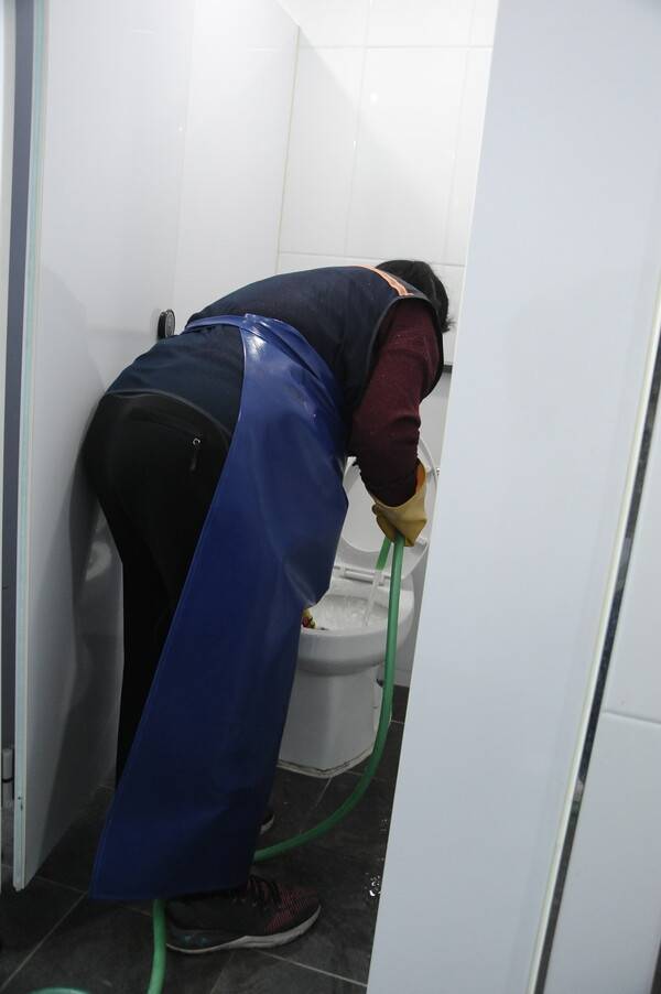 서울의 ㄷ중학교 미화노동자 이영아씨가 화장실을 청소하고 있다. 윤지연 작가 제공