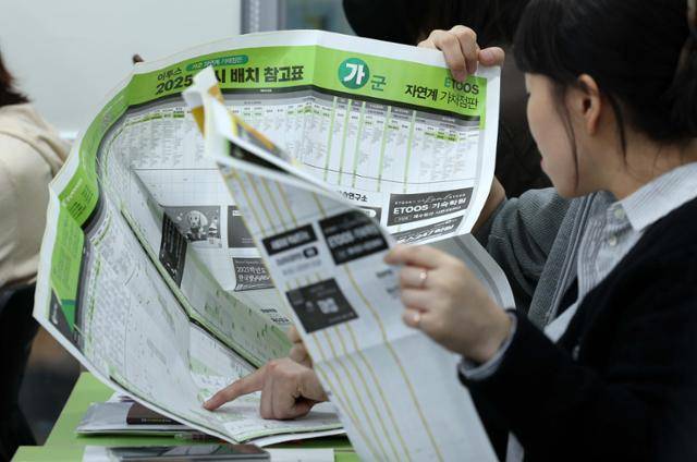 지난달 16일 오후 서울 강남구 강남하이퍼학원 본원에서 열린 2025 수능 가채점 설명회를 찾은 학부모들이 정시 배치 참고표를 살펴보고 있다. 뉴시스
