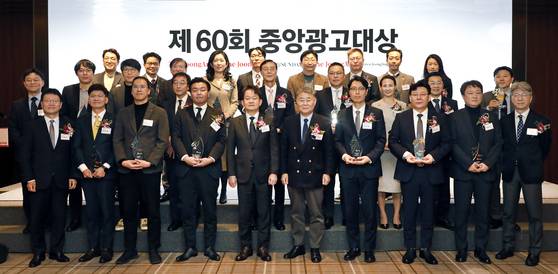 Participants of the 60th JoongAng Advertising Awards pose for a photo at the Westin Josun Seoul in central Seoul on Thursday. Korea JoongAng Daily and JoongAng Ilbo CEO Park Chang-hee, fifth from left in the front row, Professor Lee Myoung-chun from Chung-Ang University's Department of Advertising and Public Relations who headed the judge panel, sixth from left in the front row, pose with the awardees including Park Jin-young, chief public relation officer at the KB Financial Group, second from left in the front row, and Kim Cheol-woong, head of Wonju City Government’s strategic public relations team, second from left in the second row. [PARK SANG-MOON]
