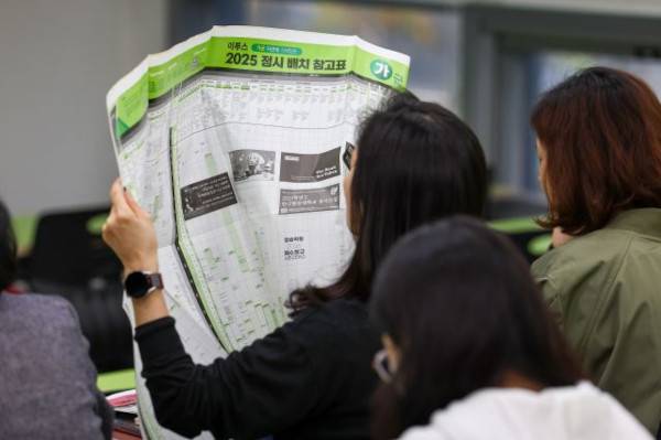 서울 강남구 강남하이퍼학원에서 지난달 16일 오전 열린 2025학년도 수능 가채점과 의약학 정시지형 설명회에서 한 참석자가 배치표를 살펴보고 있다. 연합뉴스