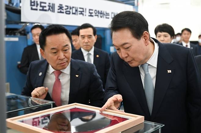 윤석열 대통령이 지난해 2월 경북 구미시 SK실트론을 방문해 전시된 실리콘 웨이퍼를 살펴보고 있다. [대통령실 제공]