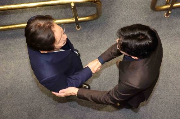 윤석열 대통령이 긴급 대국민 담화를 통해 비상계엄령을 발표한 가운데 4일 새벽 서울 여의도 국회 본회의장에서 한동훈 국민의힘 대표와 이재명 더불어민주당 대표가 악수하고 있다. 2024.12.4 뉴시스