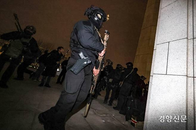 지난 4일 새벽 국회 도착한 계엄군 사이로 저격소총으로 무장한 군인의 모습. 기자가 사진을 찍자 급히 몸을 돌리고 있다. 6일 곽종근 육군 특수전사령관은 국회 국방위 소속 김병주·박선원 더불어민주당 의원과 만난 자리에서  “저격수는 절대 없었다”고 강조했다. 성동훈 기자