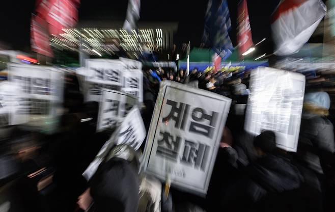 윤석열 대통령의 비상계엄 해제 요구 결의안이 국회 본회의에서 통과된 4일 새벽 서울 여의도 국회 정문 앞에 모인 시민들이 모여 있다. /사진=뉴스1