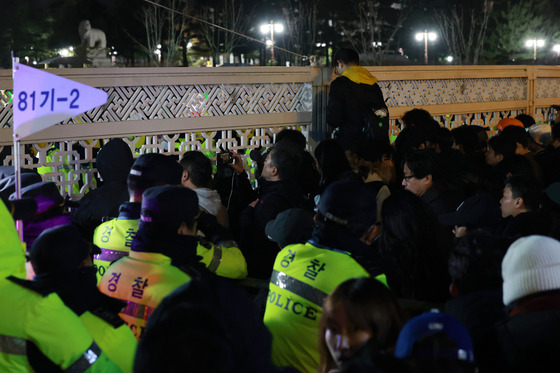 국회가 비상계엄 해제 요구 결의안을 가결한 4일 새벽 국회 앞에서 시민들이 국회 출입을 통제하는 경찰과 대치하고 있다. 〈출처:연합뉴스〉