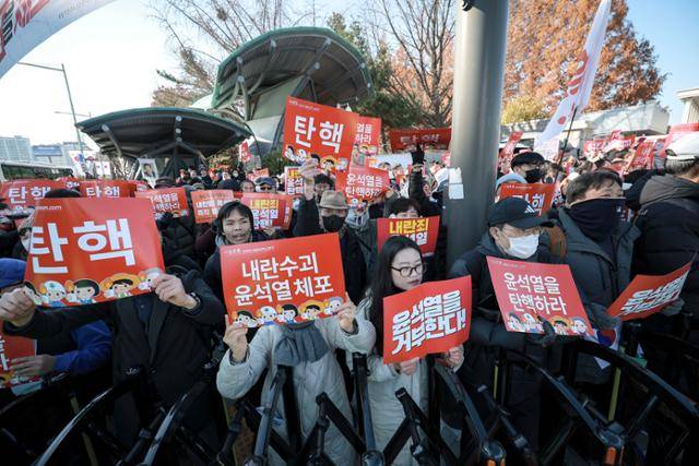 7일 서울 영등포구 국회 앞에서 시민들이 윤석열 대통령 탄핵 관련 손팻말을 들고 있다. 뉴시스