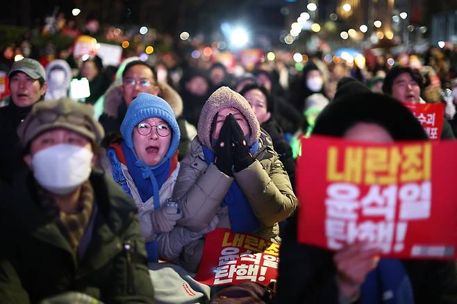 눈물 흘리는 시민들 7일 오후 서울 여의도 국회 앞에서 열린 윤석열 대통령 퇴진 촉구 집회에서 참석자들이 김건희 특검법 부결 후, 민주당 박찬대 원내대표가 국민의힘 의원들을 호명하는 동안 눈물을 흘리고 있다. [연합뉴스]