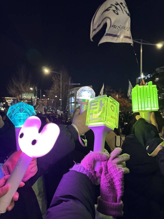응원봉을 들고 촛불 시위에 참여한 팬들. 사진| X 캡처