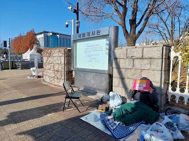 8일 국회 앞에서 밤을 지샌 시민. 사진=정경수 기자