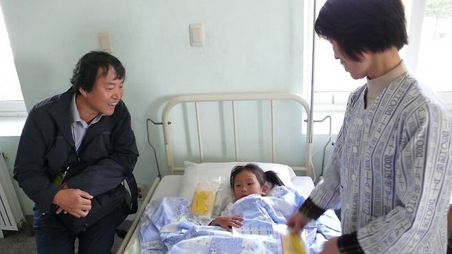 8일 별세한 정병호(왼쪽) 한양대 명예교수가 지난 2005년 ‘평양 어깨동무학용품 공장\' 준공식 참석차 방북해, 평양 어깨동무어린이병원에 입원한 북한 어린이와 함께하고 있다. 어린이어깨동무 제공