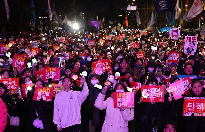 7일 오후 서울 여의도 국회 앞에서 열린 ‘내란죄 윤석열 퇴진! 국민주권 실현! 사회대개혁! 범국민촛불대행진’에서 참가자들이 공연을 지켜보고 있다. [연합]