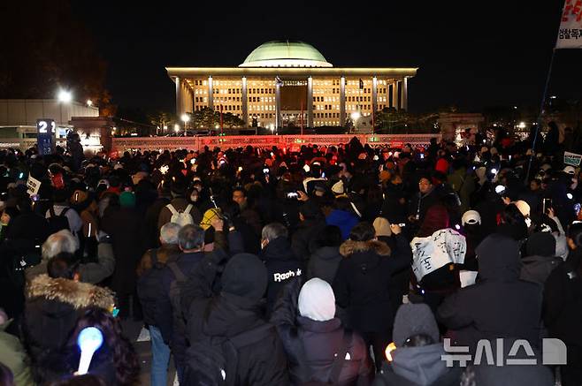 [서울=뉴시스] 황준선 기자 = 7일 서울 여의도 국회 앞에서 열린 '내란죄 윤석열 퇴진! 국민주권 실현! 사회대개혁! 국민촛불대행진'이 마무리 된 뒤 일부 시민이 남아 국회를 향해 윤석열 대통령의 탄핵을 촉구하고 있다. 2024.12.07. hwang@newsis.com