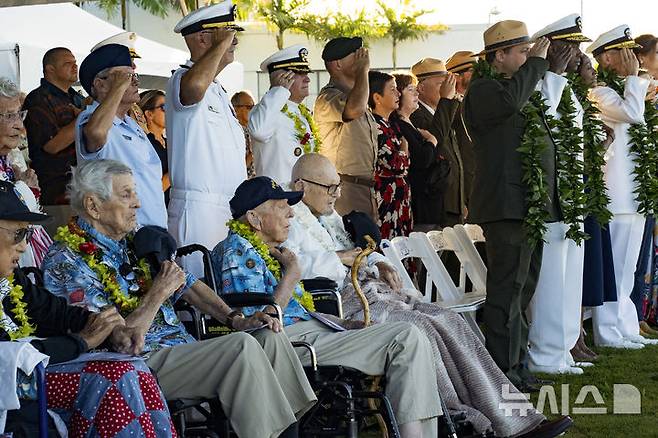 [호놀룰루( 하와이)= AP/뉴시스] 제2차 세계대전 당시 일본군의 하와이의 진주만 공습 83주년 기념식에 참석한 당시 미 해군 병사들과 가족들이 12월 7일 국가가 연주되는 동안 손을 들어 경례를 하고 있다. 2024. 12.08.