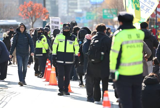 윤석열 대통령이 긴급 대국민 담화를 통해 비상계엄 해제를 선언한 4일 오전 서울 종로구 광화문광장에서 외국인 관광객들이 계엄 반대 집회를 지켜보고 있다. 연합뉴스