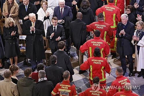 노트르담 행진하는 소방관들과 박수 보내는 참석자들 (파리 EPA=연합뉴스) 7일(현지시간) 프랑스 파리에서 열린 노트르담 대성당 재개관 기념식에서 에마뉘엘 마크롱 대통령과 도널드 트럼프 미국 대통령 당선인 등이 행진하는 소방관들에게 박수를 보내고 있다. 2024. 12. 7.