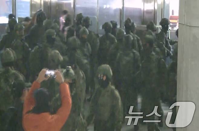 국회사무처가 계엄군의 국회 본관 진입 과정이 담긴 CCTV를 4일 공개했다. 김민기 국회사무총장은 국방부가 헬기로 24차례에 걸쳐 무장한 계엄군 230여 명을 국회 경내로 진입시켰다며 0시 40분에는 계엄군 50여 명을 추가로 국회 외곽 담장을 넘어 진입시켰다고 전했다. 사진은 국회 본관 진입을 시도하는 계엄군 모습. (국회사무처 제공) 2024.12.4/뉴스1