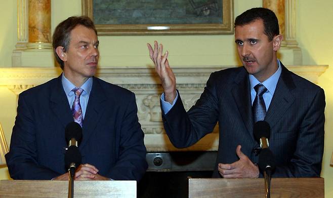 토니 블레어 전 영국 총리(왼쪽)가 2002년 12월 16일 런던 다우닝가에서 열린 공동기자회견에서 바샤르 알아사드 시리아 대통령(오른쪽)의 연설을 듣고 있다. / AFP 연합뉴스