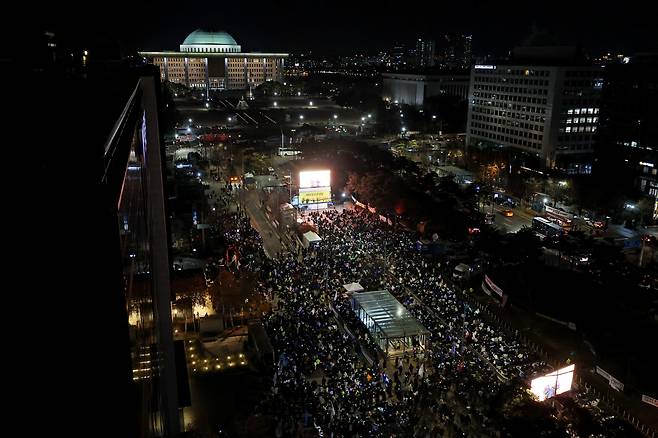 8일 오후 서울 여의도 국회 앞에서 열린 윤석열 탄핵 및 구속을 촉구하는 촛불문화제에서 참가자들이 관련 손팻말과 응원봉을 들고 있다./연합뉴스