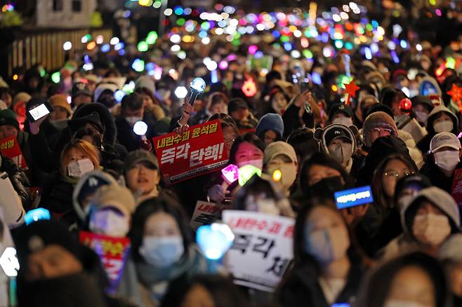 8일 오후 서울 여의도 국회 앞에서 열린 윤석열 탄핵 및 구속을 촉구하는 촛불문화제에서 참가자들이 관련 손팻말과 응원봉을 들고 있다. 연합뉴스.