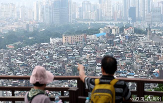 [서울=뉴시스] 추상철 기자 = 5일 오후 서울 용산구 남산에서 시민이 아파트 단지 앞으로 보이는 빌라를 바라보고 있다. 정부는 비 아파트 수요와 공급 확대를 위해 신축빌라, 오피스텔 등을 추가로 구입한 다주택자에 대해 '1가구 1주택' 특례를 주는 방안인 주택공급대책을 이르면 이번주에 발표할 예정이다. 2024.08.05. scchoo@newsis.com /사진=추상철