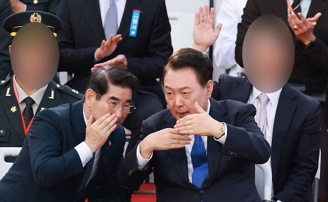 지난 10월 1일 오후 서울 광화문광장에서 열린 국군의날 기념 시가행진 당시 김용현 국방부 장관(왼쪽)과 윤석열 대통령(오른쪽)이 대화를 나누고 있다. 윤 대통령 뒤에 손을 든 정장 차림의 남자는 김 행정관으로 확인된다. (사진 출처는 뉴시스)