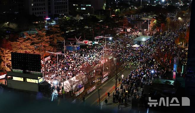 [서울=뉴시스] 전신 기자 = 8일 서울 여의도 국회 앞에서 열린 윤석열 대통령 탄핵을 촉구하는 촛불문화제에서 참가자들이 손팻말을 들고 윤 대통령 탄핵을 촉구하고 있다 2024.12.08. photo1006@newsis.com