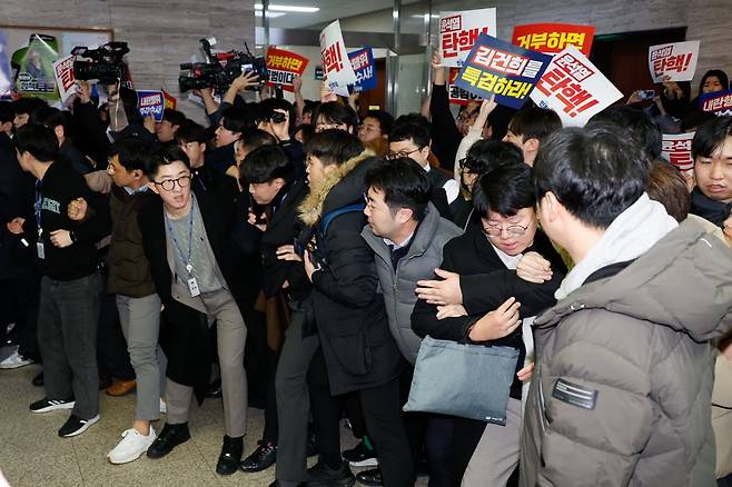 윤석열 대통령에 대한 탄핵소추안이 의결 정족수 부족으로 폐기된 7일 오후 서울 여의도 국회 국민의힘 의원총회장 앞에서 야당 당직자와 보좌관 등이 '김건희를 특검하라', '윤석열 탄핵' 등의 손팻말을 들고 항의하고 있다./ 사진=뉴스1