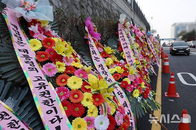 [서울=뉴시스] 조수정 기자 = 11일 서울 용산 대통령실 청사 차량출입구 앞에 윤석열 대통령을 응원하는 화환이 줄지어 세워져 있다. 2024.12.11. chocrystal@newsis.com