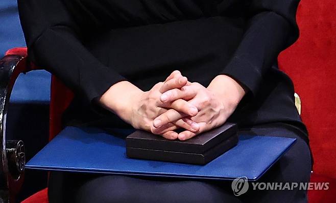 노벨문학상 메달과 증서, 한강 작가 두손에 (스톡홀름=연합뉴스) 김도훈 기자 = 2024 노벨문학상 수상자인 한강 작가가 10일(현지시간) 스웨덴 스톡홀름 콘서트홀에서 열린 시상식에서 칼 구스타프 16세 스웨덴 국왕으로부터 받은 노벨문학상 메달과 증서를 두손으로 감싸쥐고 있다. 2024.12.11 superdoo82@yna.co.kr