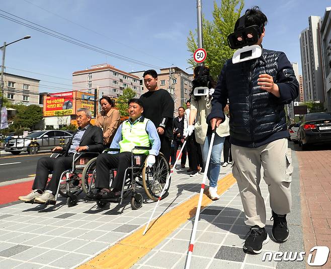 제44회 장애인의 날을 하루 앞둔 지난 4월 19일 오후 부산 남구장애인복지관 인근 보도에서 열린 명사 초청 장애인 보행환경 체험행사에서 오은택 부산 남구청장을 비롯한 참석자들이 수동 휠체어, 저시력장애 체험 고글, 시각장애인용 흰 지팡이를 사용한 채 보행약자 불편 체험을 하고 있다.ⓒ News1 윤일지 기자