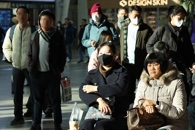 내란죄 피의자 윤석열 대통령이 긴급담화를 한 12일 오전 서울 중구 서울역 대합실에서 시민들이 텔레비전으로 담화를 시청하고 있다. 김영원 기자 forever@hani.co.kr