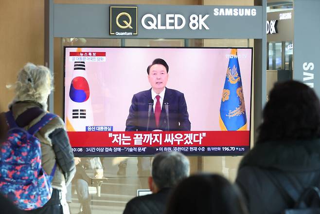 12월12일 오전 서울역에서 시민들이 윤석열 대통령 담화를 TV로 보고 있다. 연합뉴스