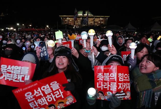 서울 여의도 국회 앞에서 지난 7일 열린 ‘내란죄 윤석열 퇴진! 국민주권 실현! 사회대개혁! 범국민촛불대행진’에서 응원봉을 든 참가자들이 탄핵안 통과를 촉구하고 있다.  연합뉴스