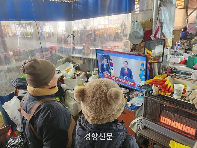 충남 공주산성시장 상인들이 12일 윤석열 대통령의 대국민 담화 방송을 시청하고 있다. 강정의 기자