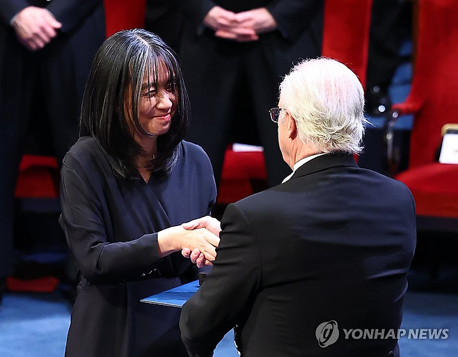 한강 작가가 10일(현지시간) 스웨덴 스톡홀름 콘서트홀에서 열린 시상식에서 칼 구스타프 16세 스웨덴 국왕으로부터 노벨문학상 메달과 증서를 받고 있다.