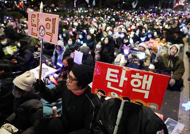 ‘윤석열 즉각 퇴진·사회대개혁 비상행동’이 13일 오후 서울 영등포구 국회의사당 인근에서 연 탄핵소추안 국회 통과 촉구 촛불집회에서 참가자들이 손팻말을 들고 있다. [연합뉴스]