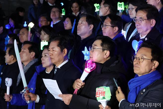 [서울=뉴시스] 조성우 기자 = 박찬대 더불어민주당 원내대표가 13일 오후 서울 여의도 국회 본관 앞 계단에서 당 소속 의원들과 함 응원봉을 들고 윤석열 대통령 탄핵 촉구 결의문을 낭독하고 있다. 2024.12.13. xconfind@newsis.com /사진=조성우