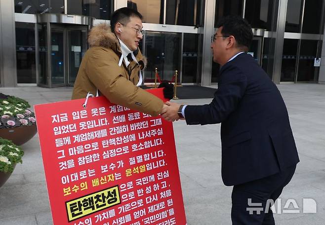 [서울=뉴시스] 조성봉 기자 = 김상욱 국민의힘 의원이 13일 오전 서울 여의도 국회 본청 입구에서 국민의힘 의원들에게 윤석열 대통령 탄핵 찬성 투표를 호소하는 1인 시위를 하던 중 김태선(오른쪽) 더불어민주당 의원의 격려를 받고 있다. 2024.12.13. suncho21@newsis.com