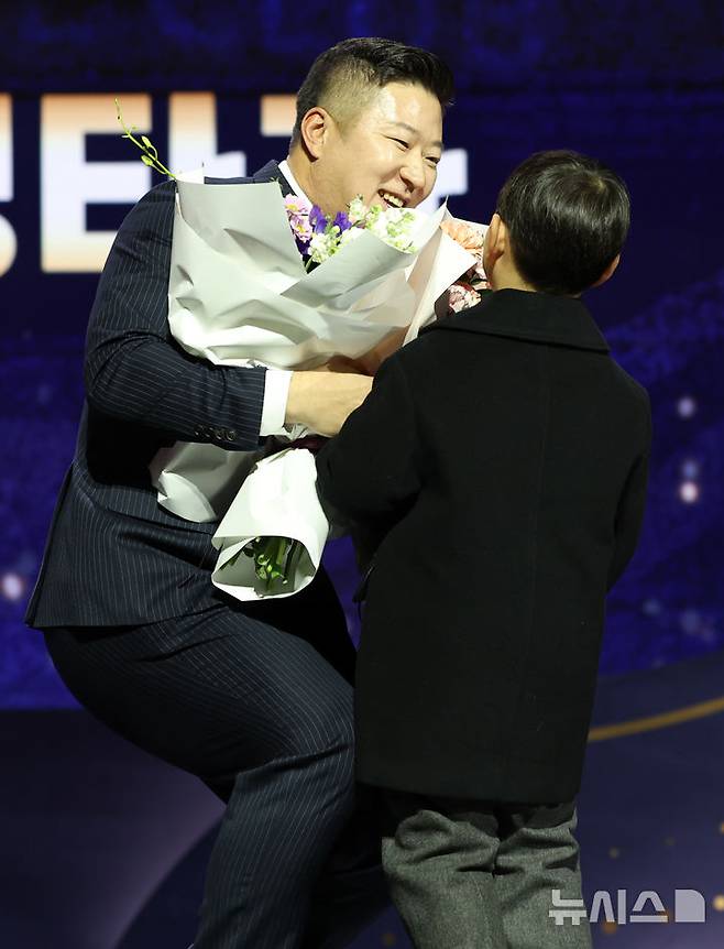 [서울=뉴시스] 이영환 기자 = KIA 타이거즈 최형우가 13일 오후 서울 강남구 코엑스 오디토리움에서 열린 2024 KBO 골든글러브 시상식에서 지명타자부문 골든글러브를 수상한 후 아들에게 꽃다발을 받고 있다. 2024.12.13. 20hwan@newsis.com