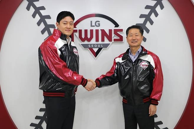 불펜 투수 김강률(왼쪽)이 13일 잠실구장 LG 사무실에서 FA 계약을 한 후 김인석 LG스포츠 대표이사와 악수하고 있다.   LG 트윈스 제공