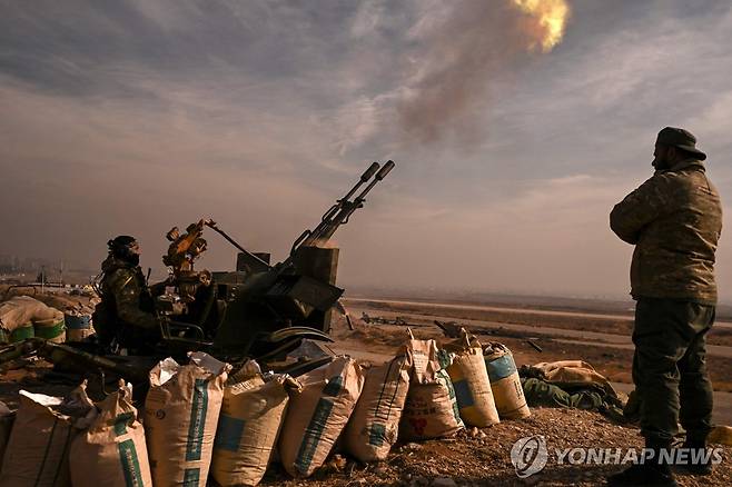 시리아 반군 (AFP 연합뉴스) 12일(현지시간) 시리아 수도 다마스쿠스 장악한 반군이 대공포 쏘는 모습. 2024.12.13 dk@yna.co.kr