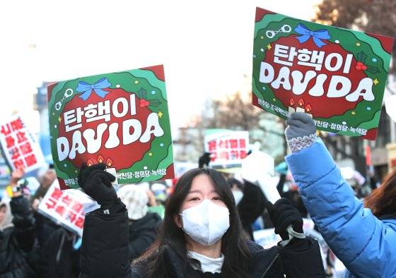 윤석열 대통령에 대한 2차 탄핵소추안 국회 표결이 열린 14일 대구 중구 국채보상로를 가득 메운 시민들이 '탄핵이 DAVIDA(답이다)'라고 적힌 피켓을 들어보이며 탄핵소추안 가결을 촉구하고 있. 뉴스1