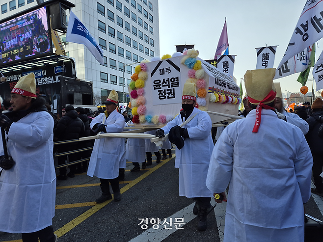 전국농민회총연맹 소속 농민들이 14일 ‘근조 윤석열 정권’이라 적힌 상여를 메고 서울 여의도 국회의사당 방면으로 행진하고 있다. 이예슬 기자